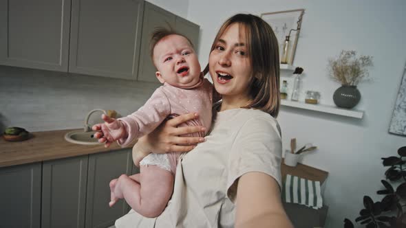 Woman with Crying Baby in Kitchen