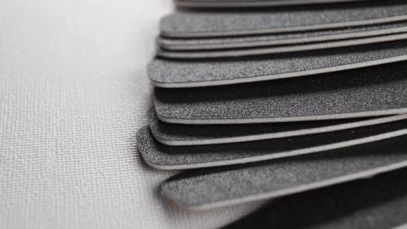 Black rough grained flexible nail files for manicure and pedicure. Macro. Rotation