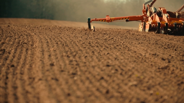 Tractor Plowing Field At Sunset