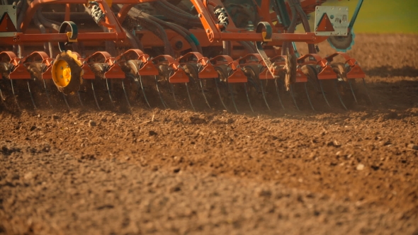 Tractor Plowing Field At Sunset