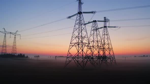 Aerial View High Voltage Steel Power Pylons in Field Covered with Fog Countryside