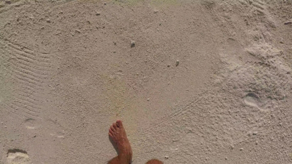 Male Feet Walking Along Sandy Beach