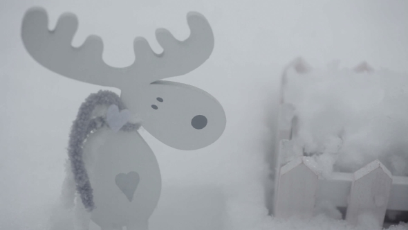 Wooden Toy Moose And a Small Fence In The Snow