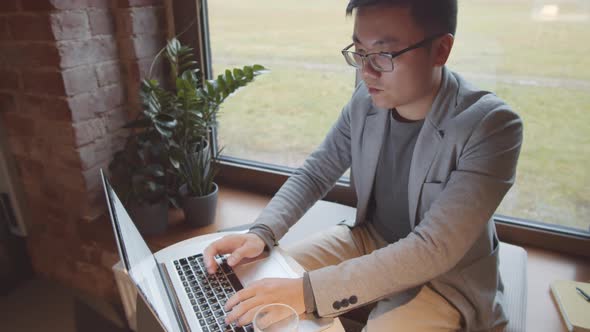 Male Freelancer Working in Coworking Cafe