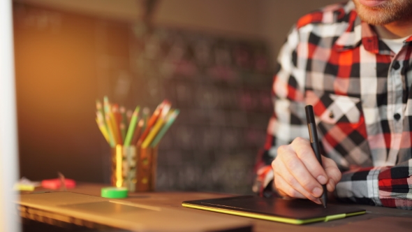 Creative Businessman Writing On Graphic Tablet While Using Laptop In Office