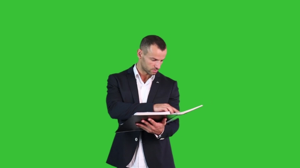 A Man In a Suit Looking Documents On Green Background