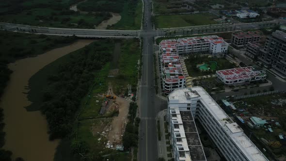 Fly in over new development,wetlands and roads revealing river and city skyline view with high rise