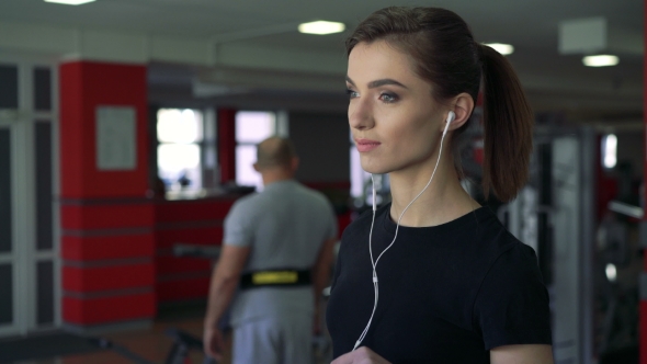  Of a Girl With Headphones On a Treadmill