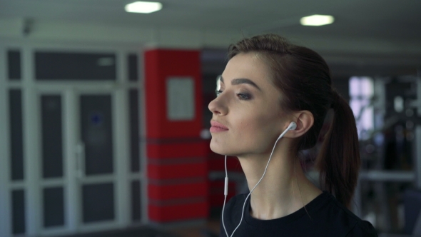 Girl With Headphones On a Treadmill