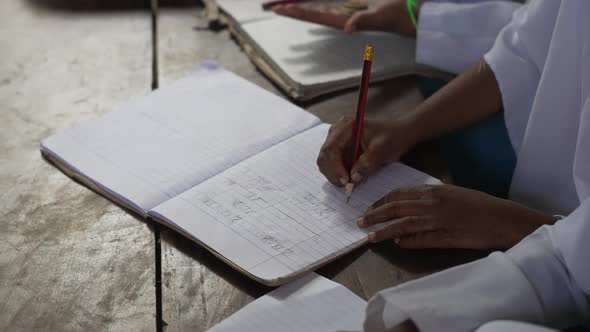 Muslim arabic girl at school writing in her notebook. Education in the islamic countries. Close up s