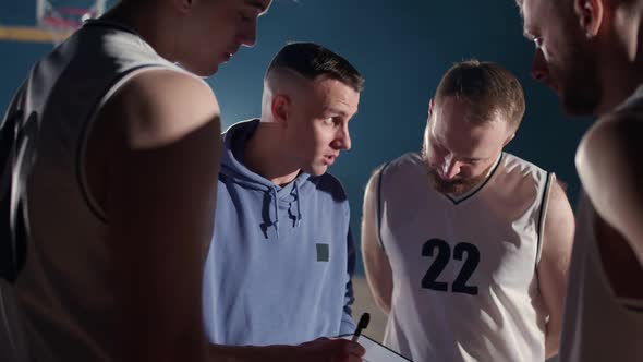 Basketball Championship the Coach Instructs Player Team on the Tactics Game Using a Tablet and a