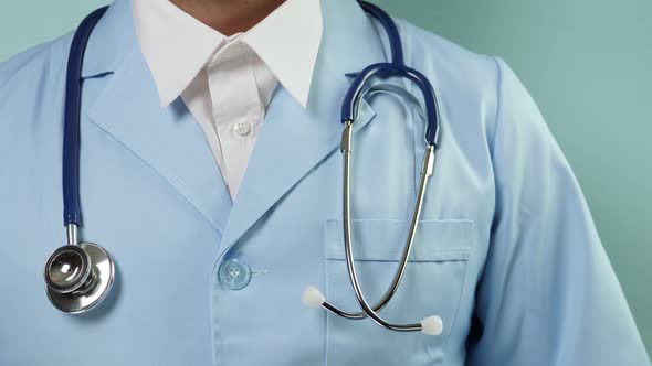 Doctor in Medical Suit with Stethoscope and Blue Gloves Corrceting Clothes