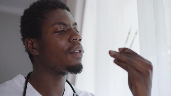 Headshot Portrait Thoughtful Expert African American Man Examining Vax Ampoules