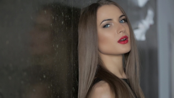 Brunette With Red Lips Posing At The Wall