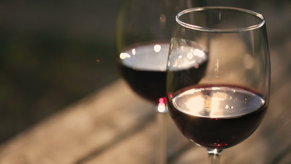 Two Glasses Of Red Wine On a Wooden Table.