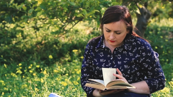 Attractive Woman Reading Book  In Park.