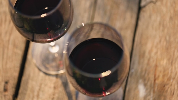 Two Glasses Of Red Wine On a Wooden Table.