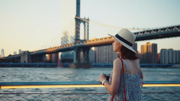 Attractive girl with retro camera at the Manhattan bridge