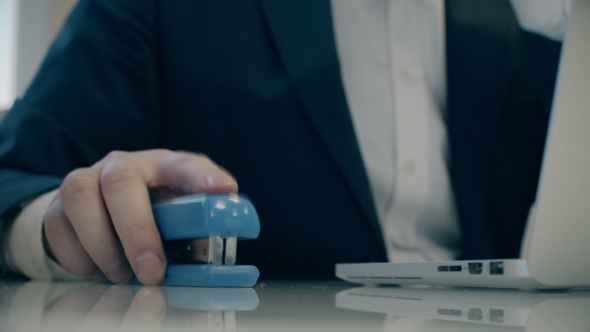 Businessman Uses Stapler Like a Mouse. Office Fun