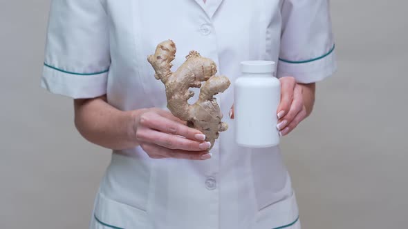 Nutritionist Doctor Healthy Lifestyle Concept - Holding Ginger Root and Jar of or Vitamine Pills