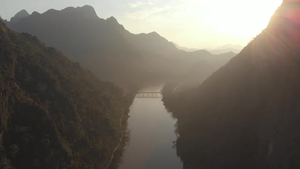 Aerial: flying over Nam Ou River Nong Khiaw Muang Ngoi Laos, sunset dramatic sky