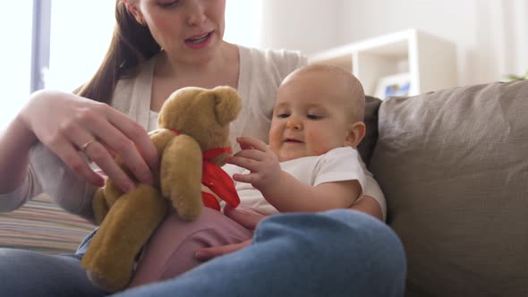 Mother and Baby Playing with Teddy Bear at Home