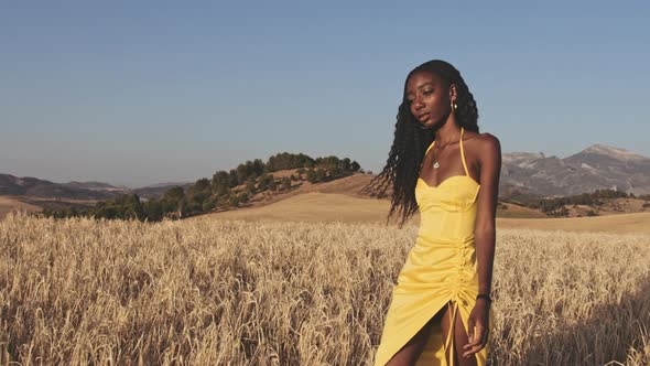 Woman Walking in Field with Seams of Her Dress Gently Moving with the Wind