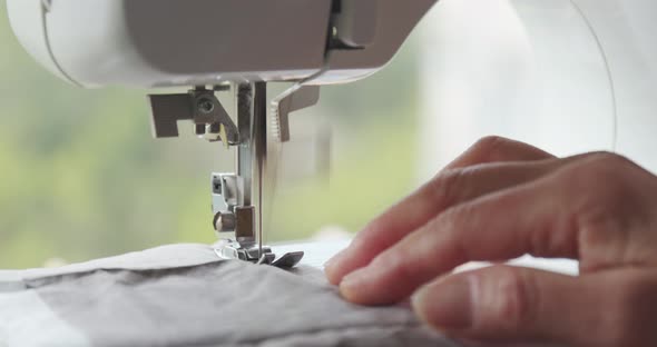 Woman stitching on fabric with sewing machine