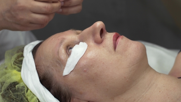 Cosmetologist Put Cotton Pad Under Eye Woman In Beauty Saloon. Permanent Dyeing 