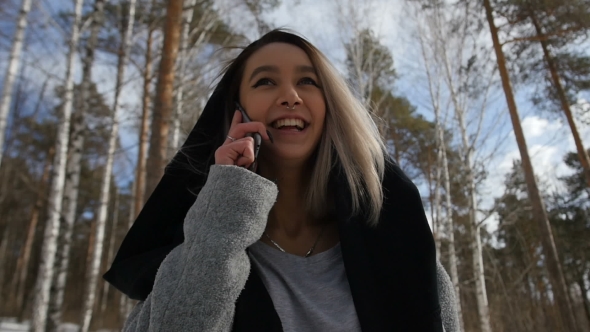 Girl Talking on the Phone Walking in the Woods