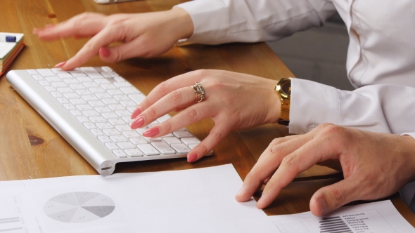 Woman And Man Working In An Office Typing On The Keyboard
