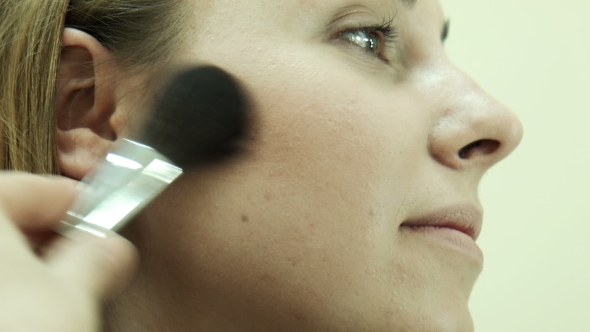 The Makeup Artist Applying Powder Using Brush