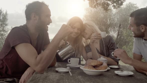 Group of Four Happy Men and Women Friends Smile Laugh and Drink Coffee During Italian Breakfast in