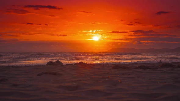 Cinemagraph of a beautiful sunset with the waves moving gently at a beach in Italy.