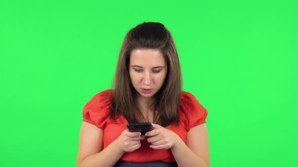 Portrait of Cute Girl Texting on Her Phone. Green Screen