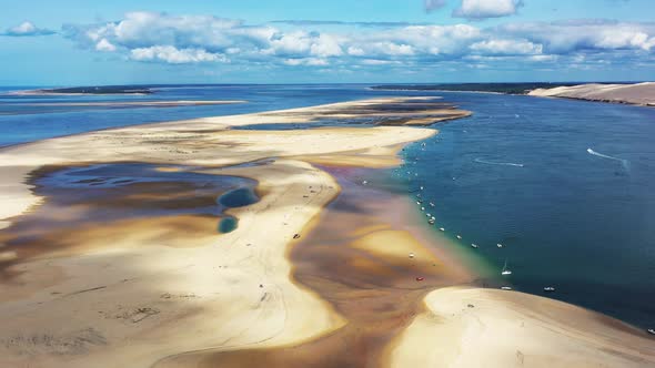 Banc d'Arguin in Arcachon Bassin France with boats anchored in a row along the edge, Aerial dolly ri