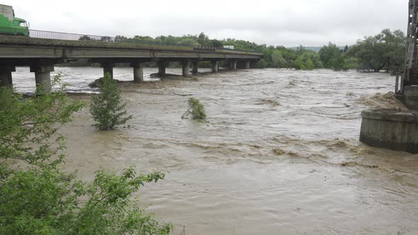 Bridge Over the Overflowing River. Stormy Water Flows. Extremely High Water Level in the River