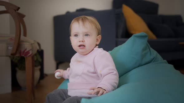 Cute baby girl playing at home and smiling to the camera