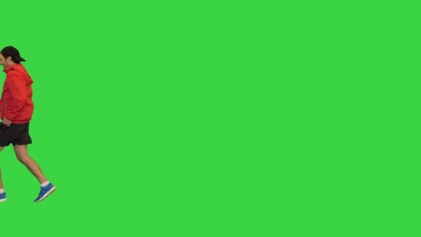 Sporty Man in a Cap Running By on a Green Screen Chroma Key