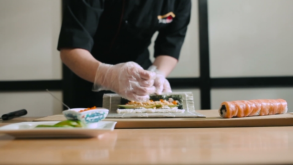 Sushi Chef Preparing Rolls Using a Bamboo Mat