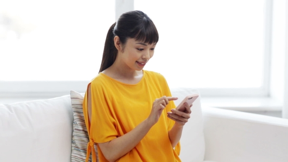 Happy Asian Woman With Smartphone At Home