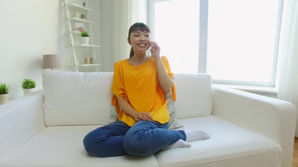 Happy Asian Woman Calling On Smartphone At Home