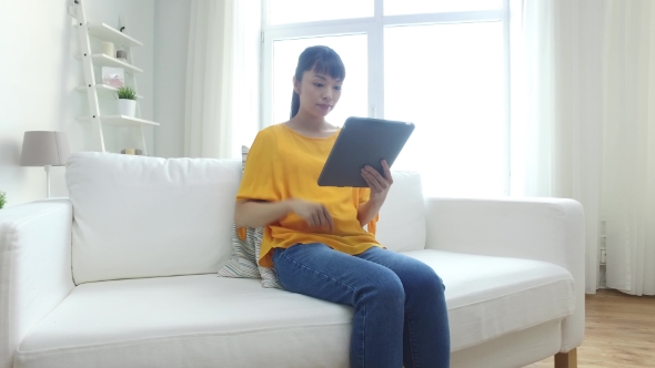 Happy Young Asian Woman With Tablet Pc At Home