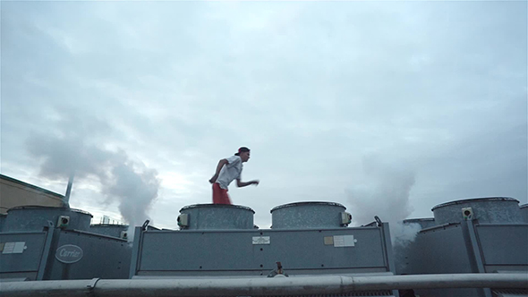 Young Male Tracer On Building Roof