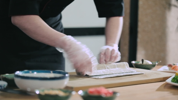 Sushi Master Preparing Rolls Using a Bamboo Mat