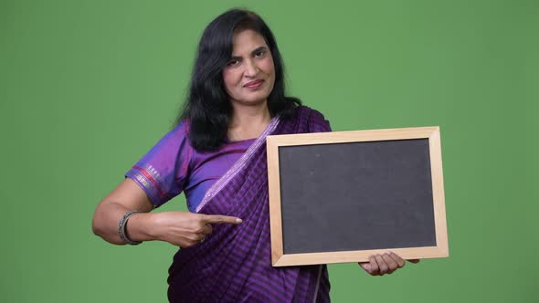 Mature Beautiful Indian Woman Pointing To Blackboard