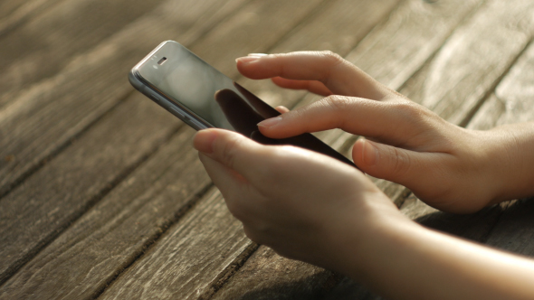 Typing Smartphone On Wood Desk alt