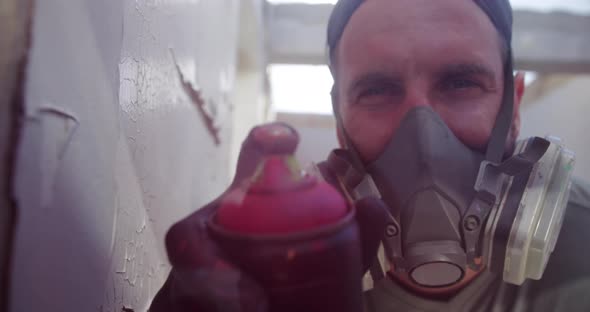 Graffiti artist spraying spray paint at camera 4k