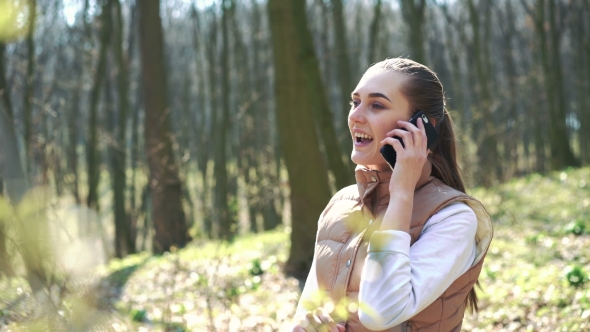 Young Girl Speaks By Phone In The Forest