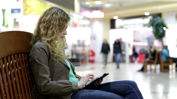 Young Woman With Tablet Sit On Bench In Shopping Mall